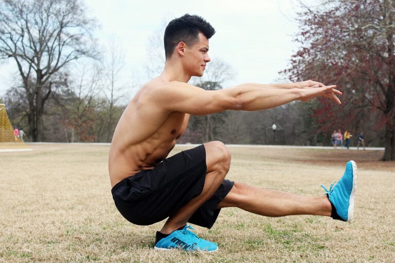 Man performing bodyweight squat outdoors for strength training workout